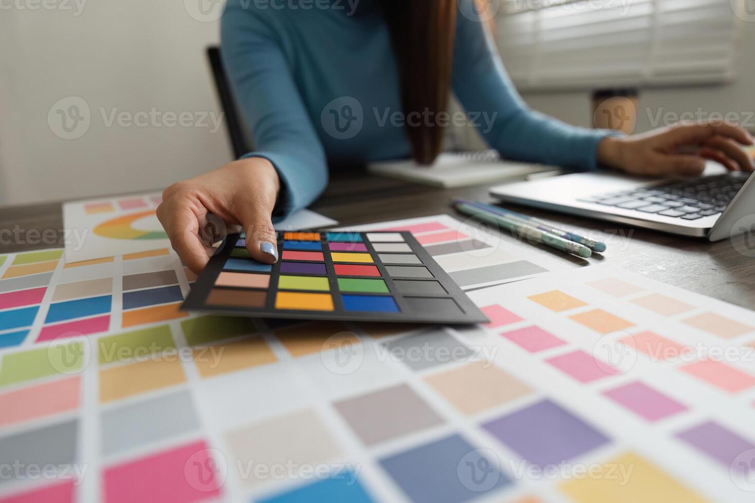 Palette Selection and Design Focus. A professional designer evaluating color options using swatches in a stylish workspace. photo