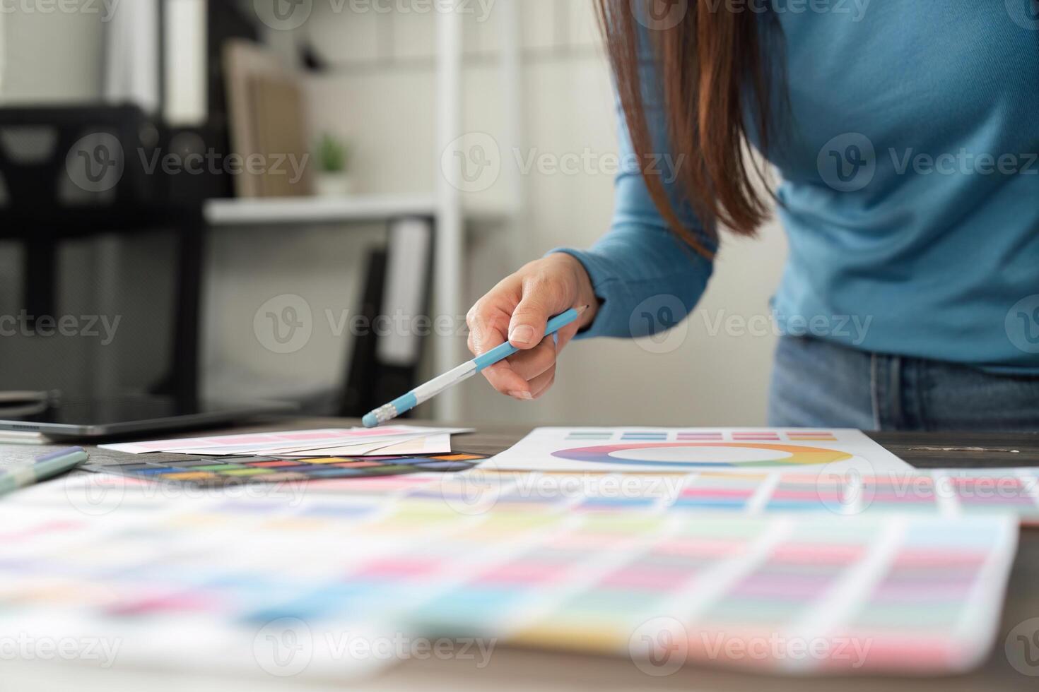 Design Process and Color Selection. A designer carefully evaluates color samples and palettes to enhance their project. photo
