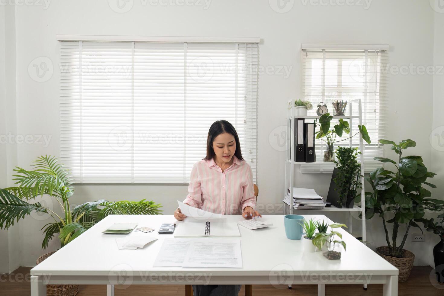 Home Office and Document Management. An individual sorting through paperwork while seated in a bright home office. photo
