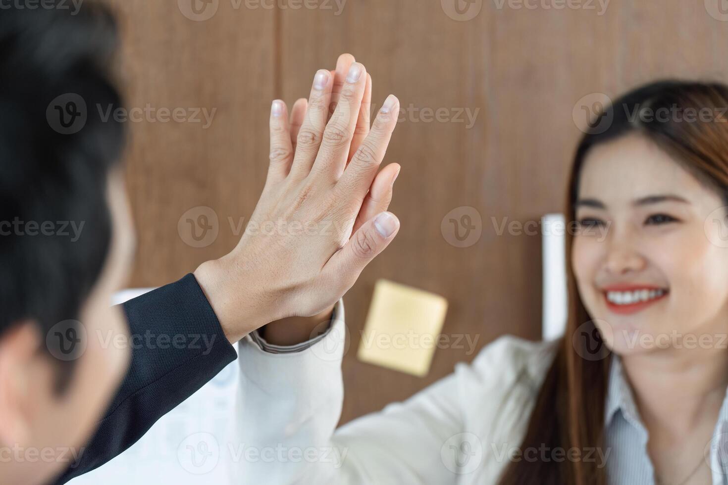 Collaboration and Teamwork. A celebratory high-five highlights a successful partnership in a professional setting. photo