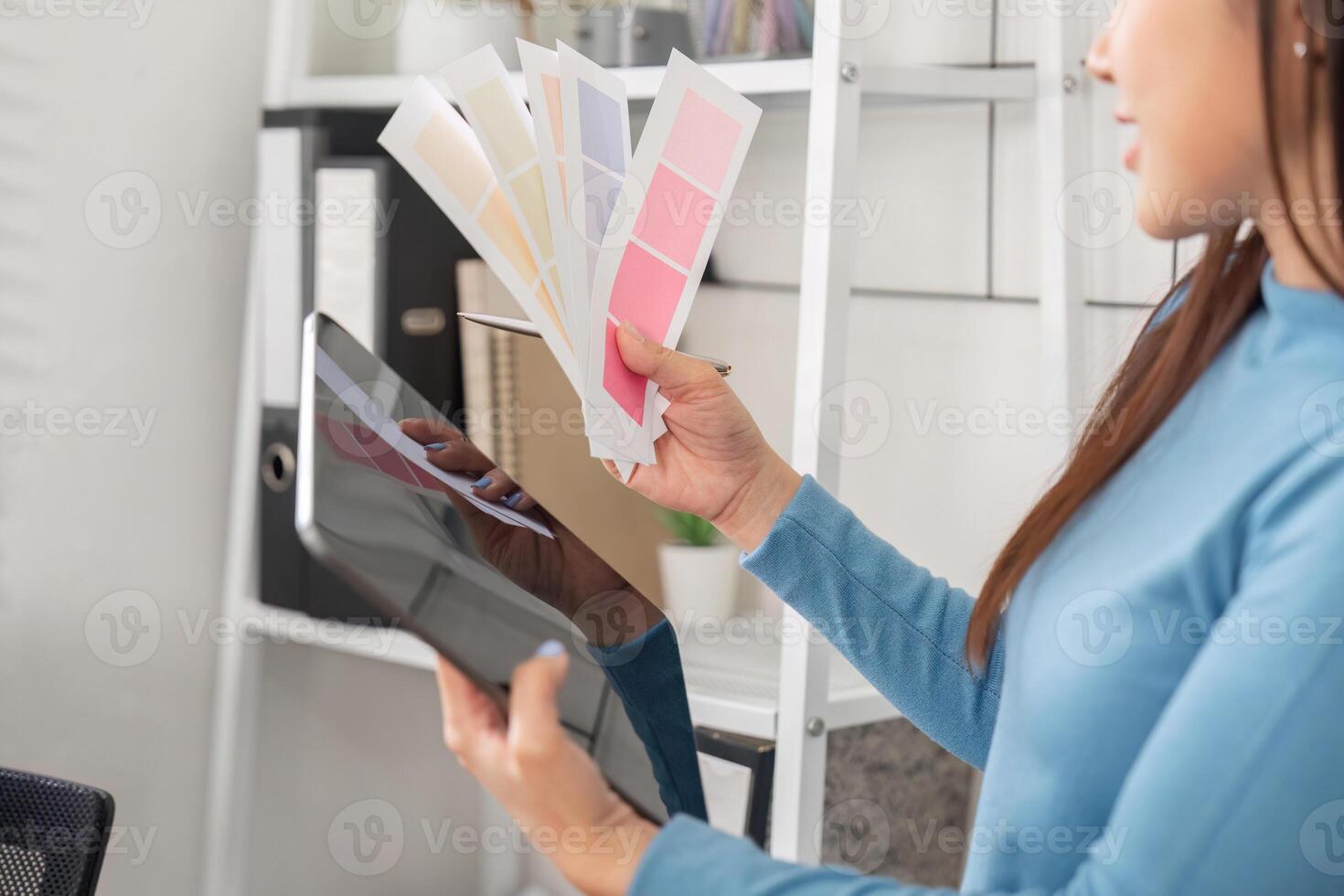 Color Choice and Design Collaboration. A designer weighing color options and utilizing a tablet for project inspiration. photo