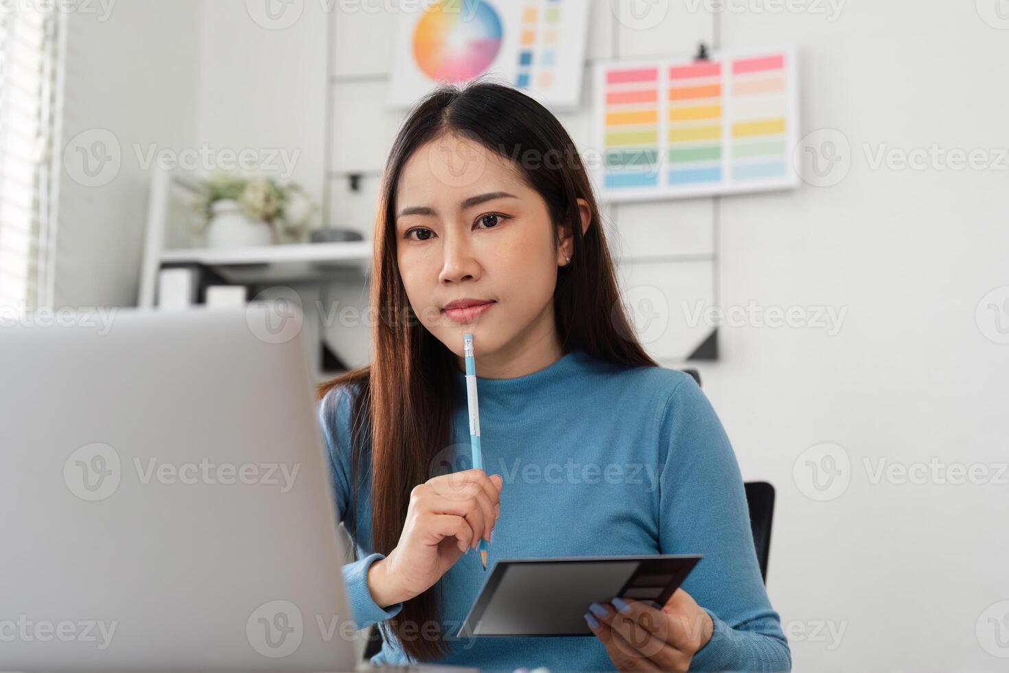 Color Selection and Design Process. A designer contemplating color choices using a tablet and swatches in a modern workspace. photo
