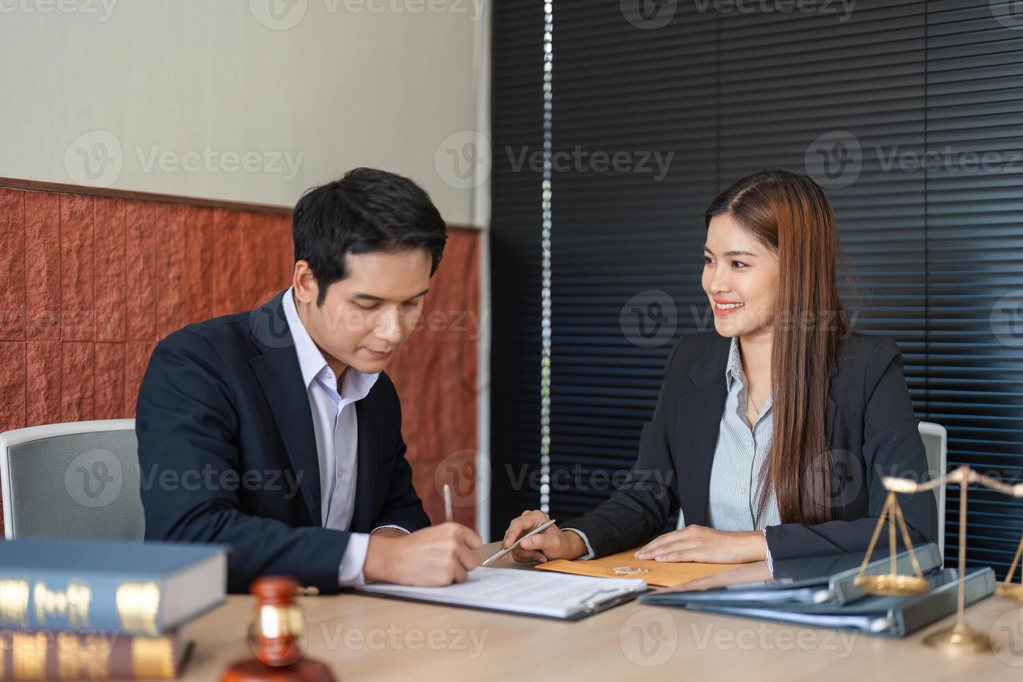 Client Consultation and Document Preparation. A lawyer collaborating with a client on important legal matters in her office. photo