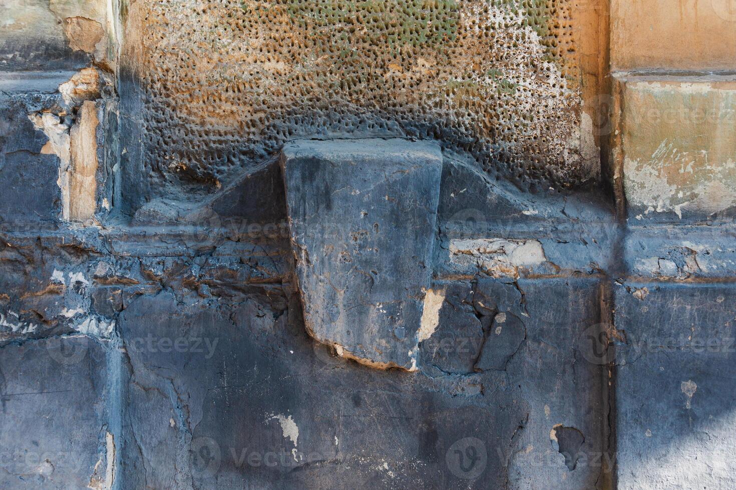 Detailed textures of an old wall reveal years of weathering and decay, creating an intriguing surface. photo