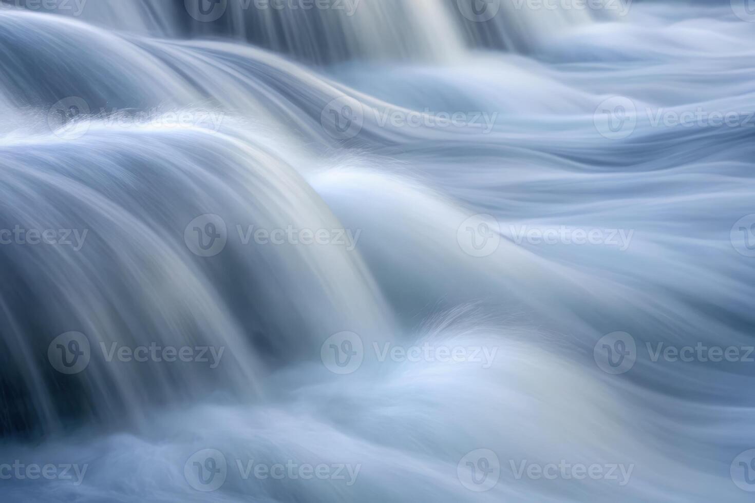 Flowing water cascades gently over smooth stones in a serene natural setting photo