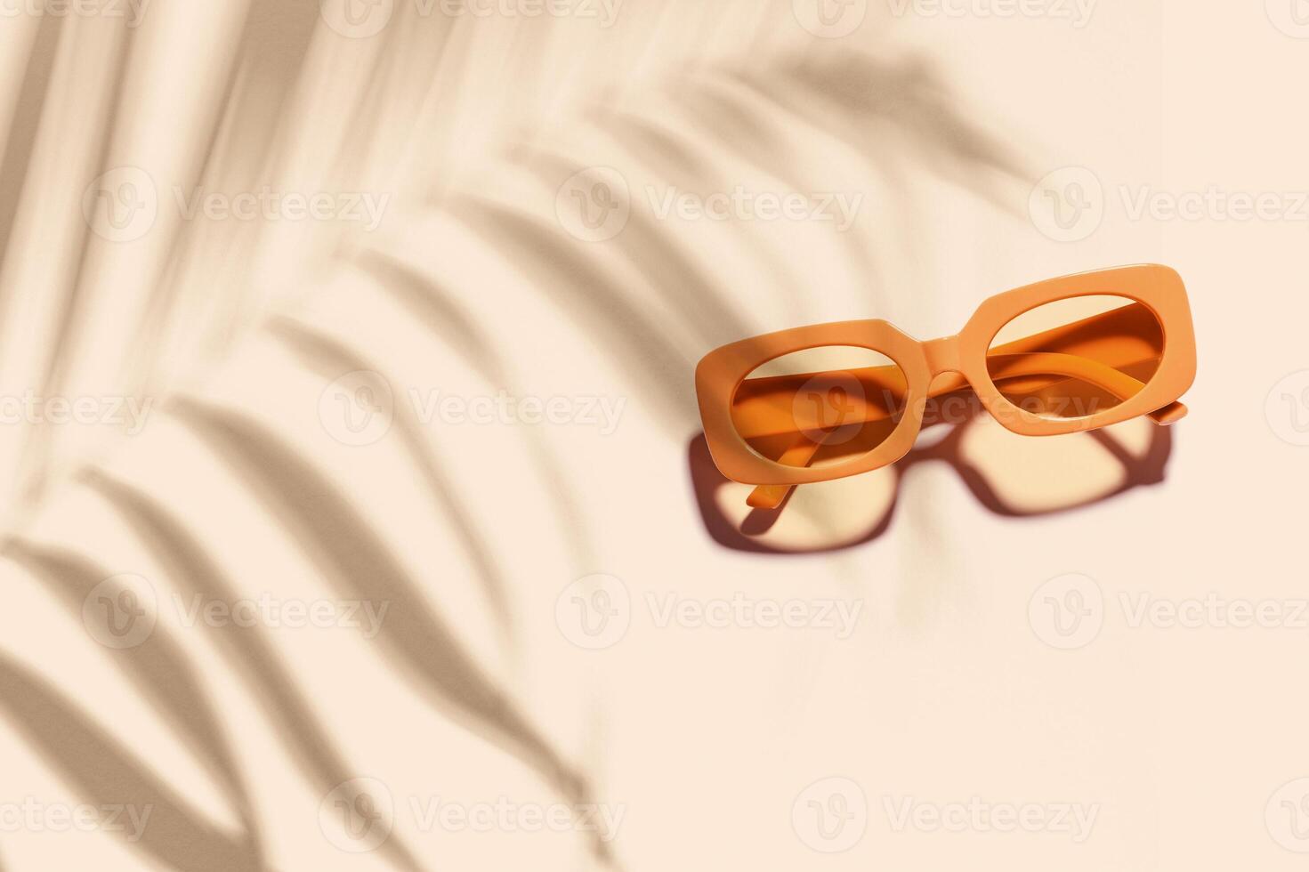 Trendy sunglasses with orange Frame on neutral beige background, copyspace, beach vibes, summertime mood concept, palm leaf shadow, summer fashion glasses. Minimal top view of eyeglasses photo