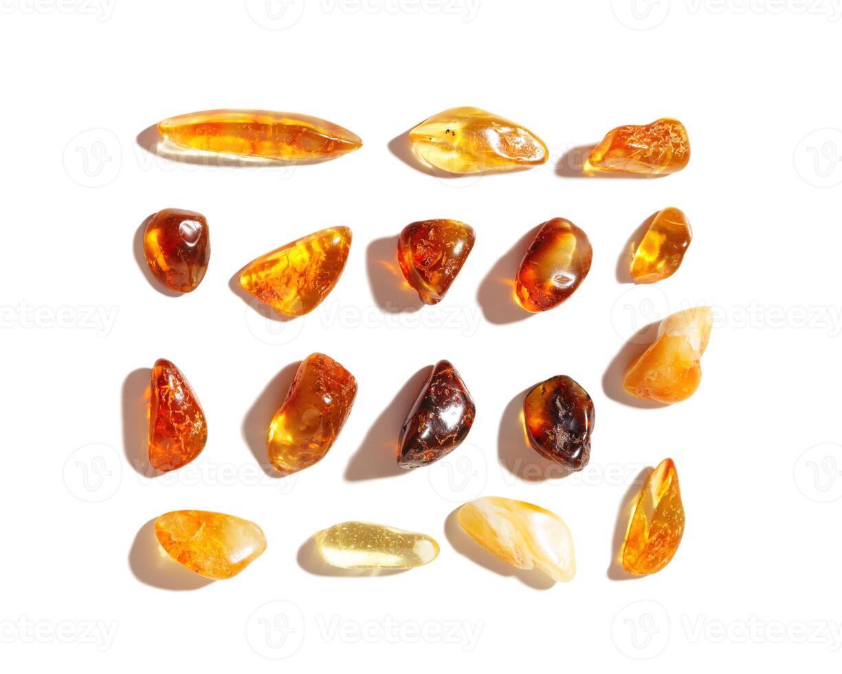 Set of Natural gemstone amber stones at sunlight, yellow orange gradient color isolated on white background. Natural mineral. Aesthetic Amber gems flatlay pattern, pieces ancient resin photo