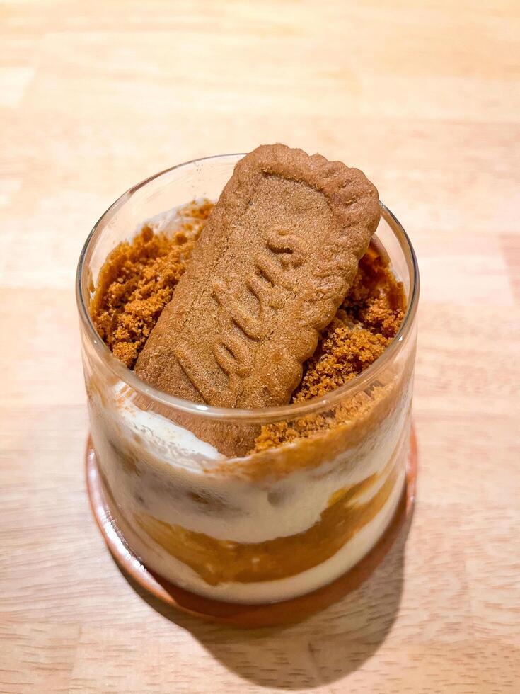 A cookie in a glass with a spoon on top photo