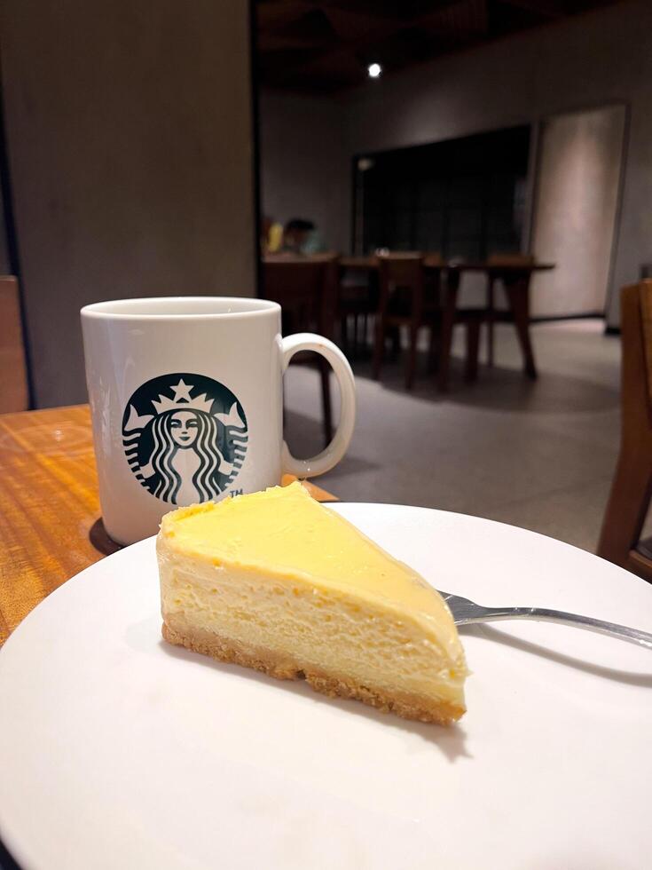Starbucks coffee and cheesecake on a table. Bandung, Indonesia March 12, 2025 photo