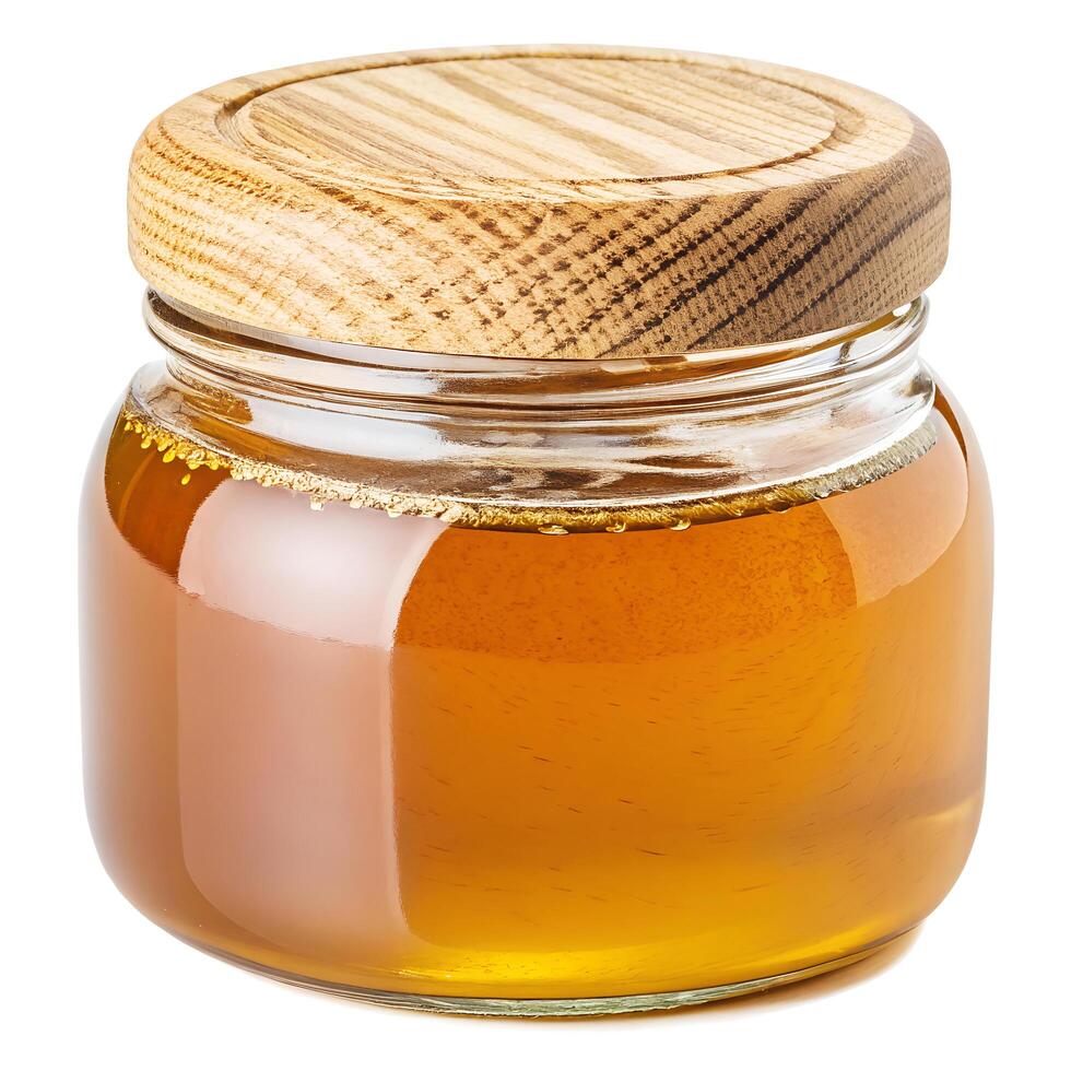 Glass Jar of Golden Honey with Wooden Lid on White Background photo
