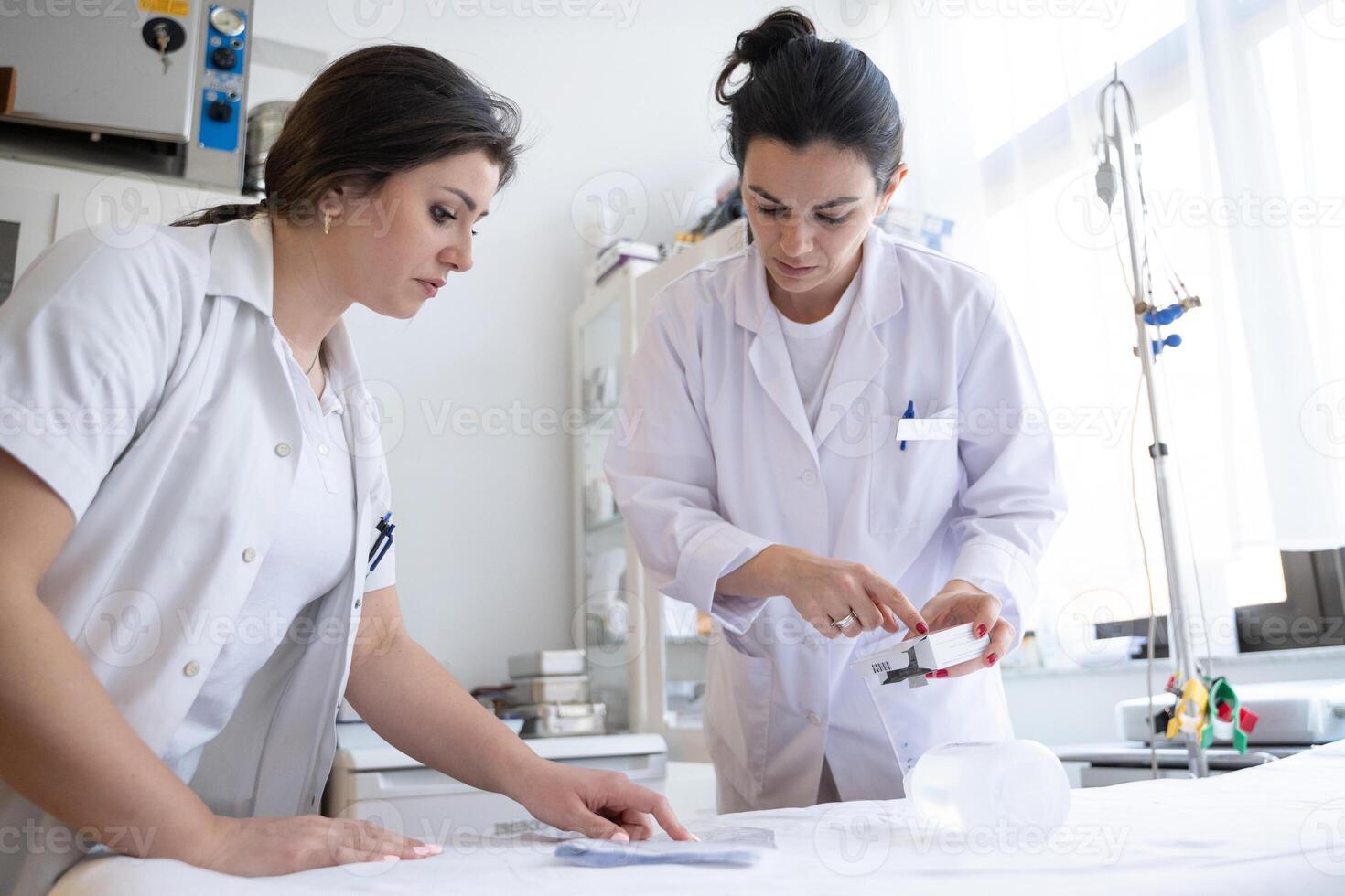 Two nurses in a hospital laboratory are carefully inspecting and preparing medications for patients and hospital use. photo