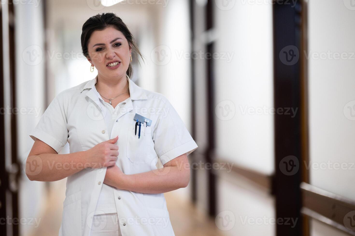 A dedicated nurse in uniform walks briskly down a well-lit hospital corridor, reflecting professionalism and urgency in a healthcare setting. photo