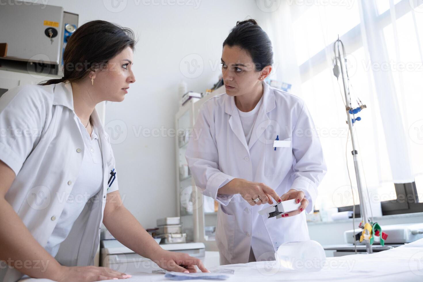 Two nurses in a hospital laboratory are carefully inspecting and preparing medications for patients and hospital use. photo