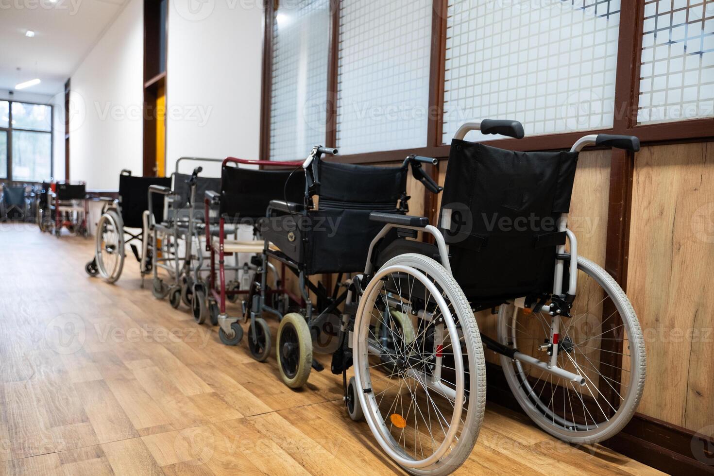 A row of wheelchairs neatly lined up in a hospital corridor, ready for patients in need of mobility assistance photo