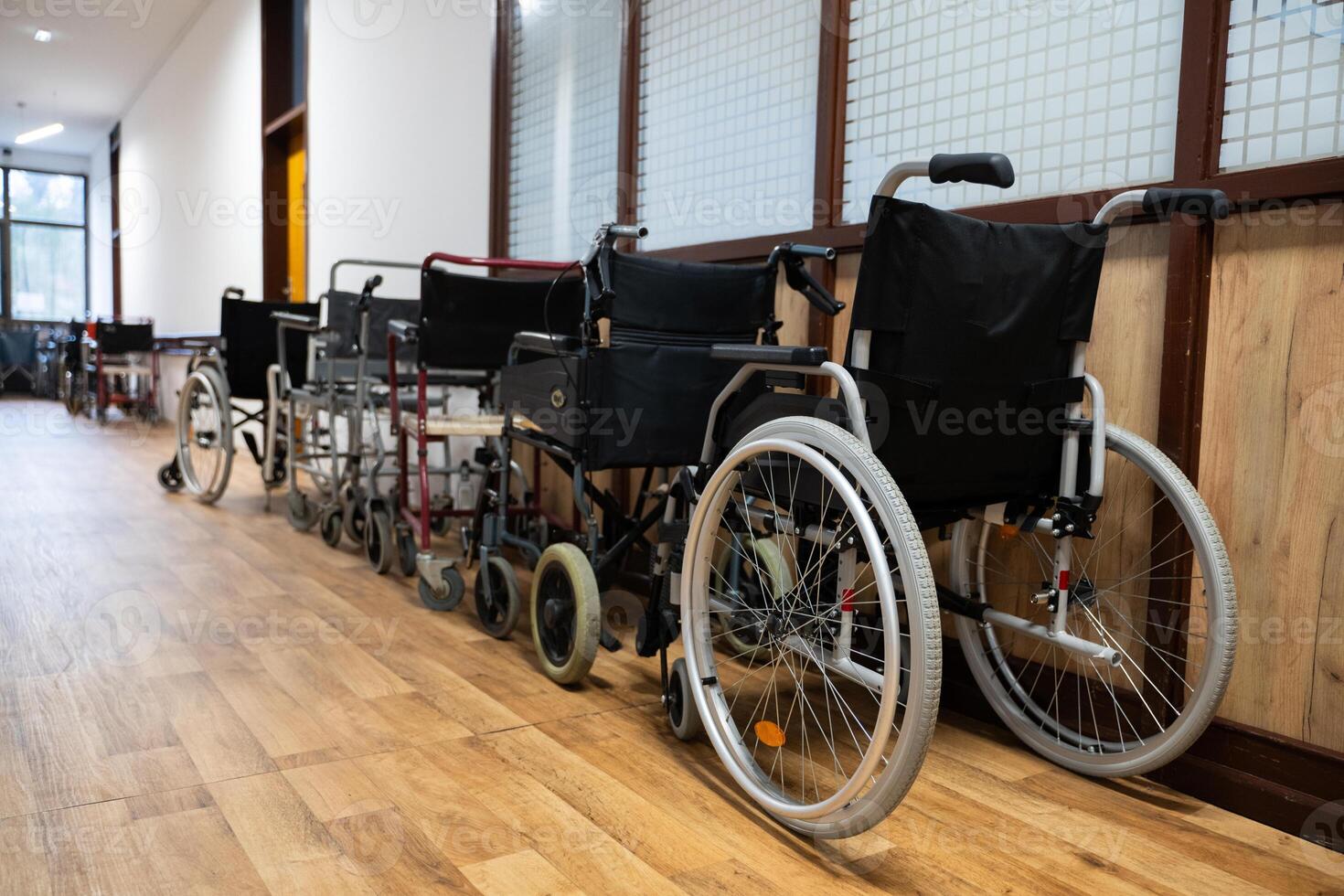 A row of wheelchairs neatly lined up in a hospital corridor, ready for patients in need of mobility assistance photo