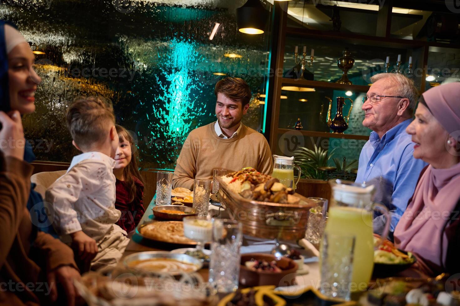 Grandparents arrive at their children's and grandchildren's gathering for iftar in a restaurant during the holy month of Ramadan, bearing gifts and sharing cherished moments of love, unity, and photo