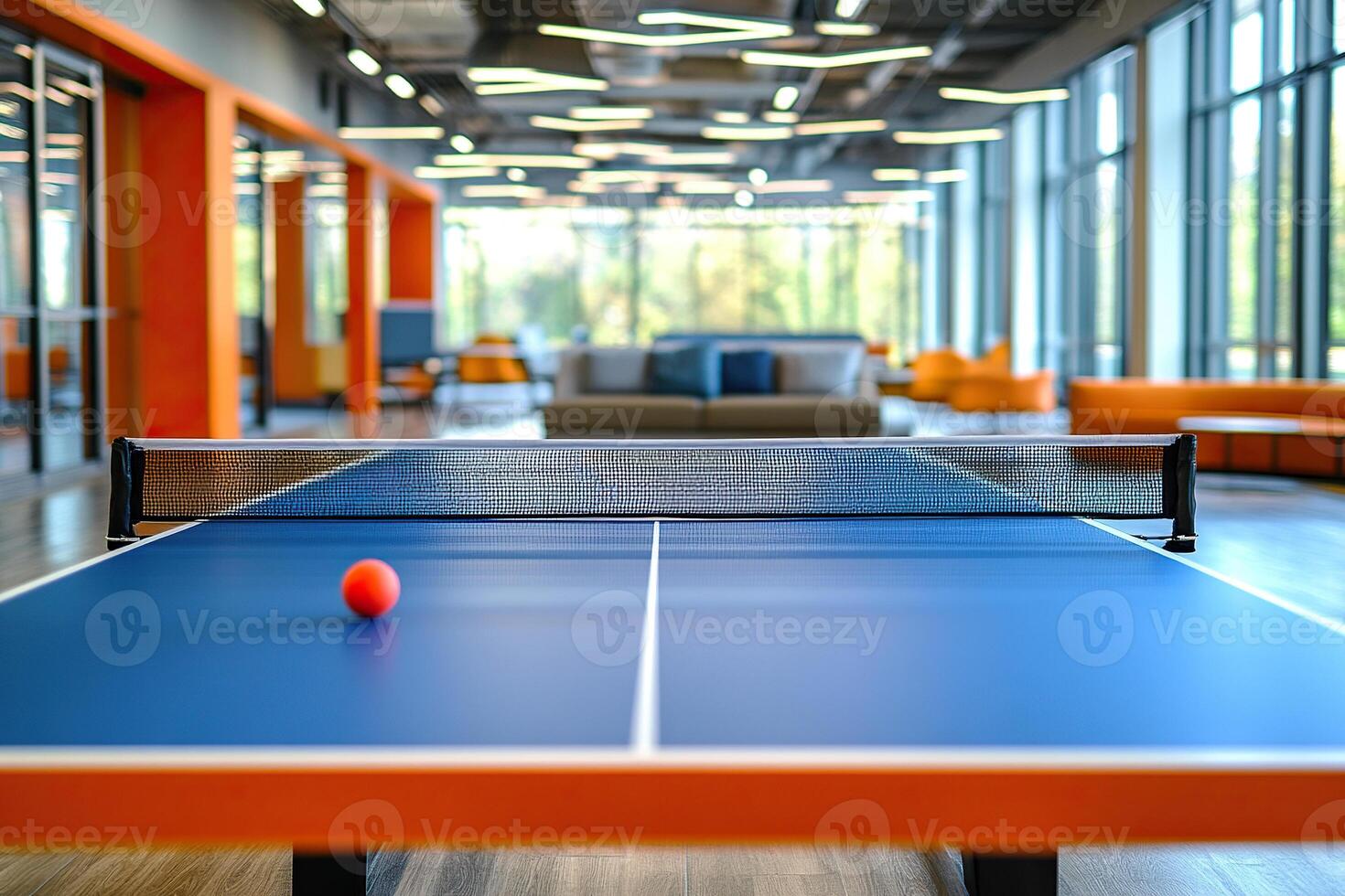 A blue table tennis table stands in a modern office space, serving as both a place to relax and a stylish design element. The concept of relaxation at work to improve employee productivity. photo