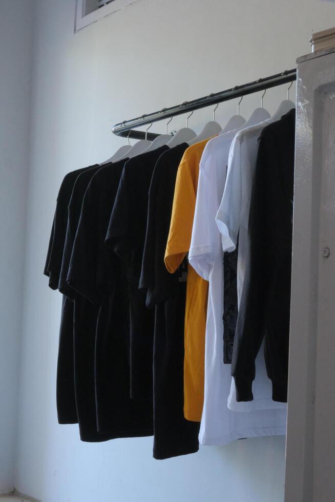a rack of shirts hanging on a wall photo