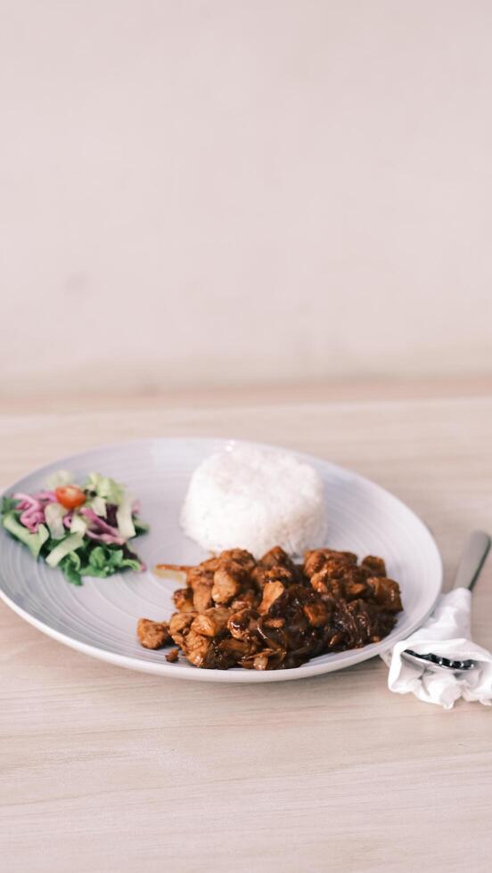 chicken fried rice with vegetables and salad on white plate photo
