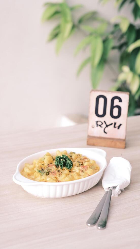 the white plate with pasta and the number 60 is on the table photo