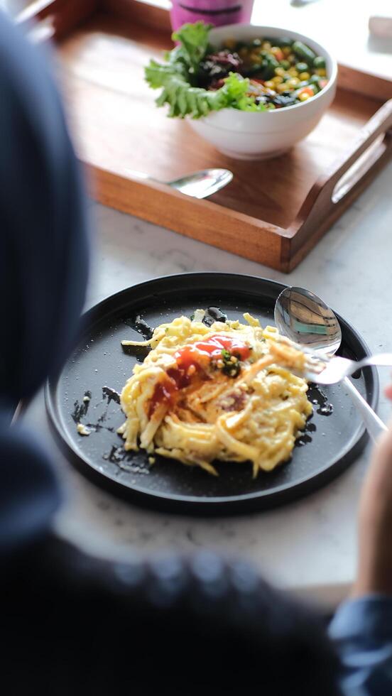 a person sitting at a table with a plate of food photo