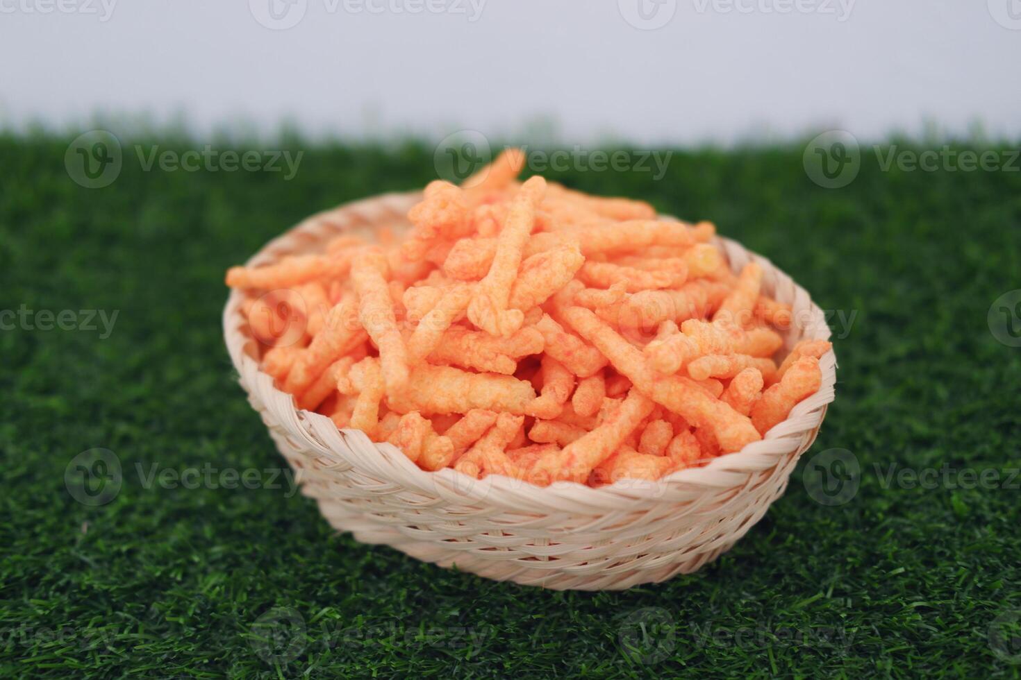 a woven basket filled with crunchy, bright orange snack sticks photo