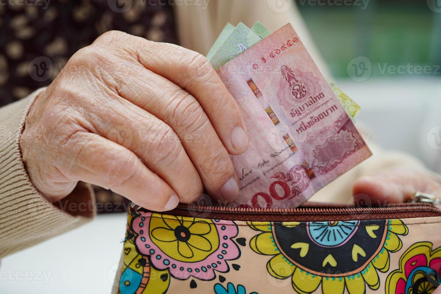 Asian senior or elderly old lady woman holding counting coin money in bag. Poverty, saving problem in retirem photo
