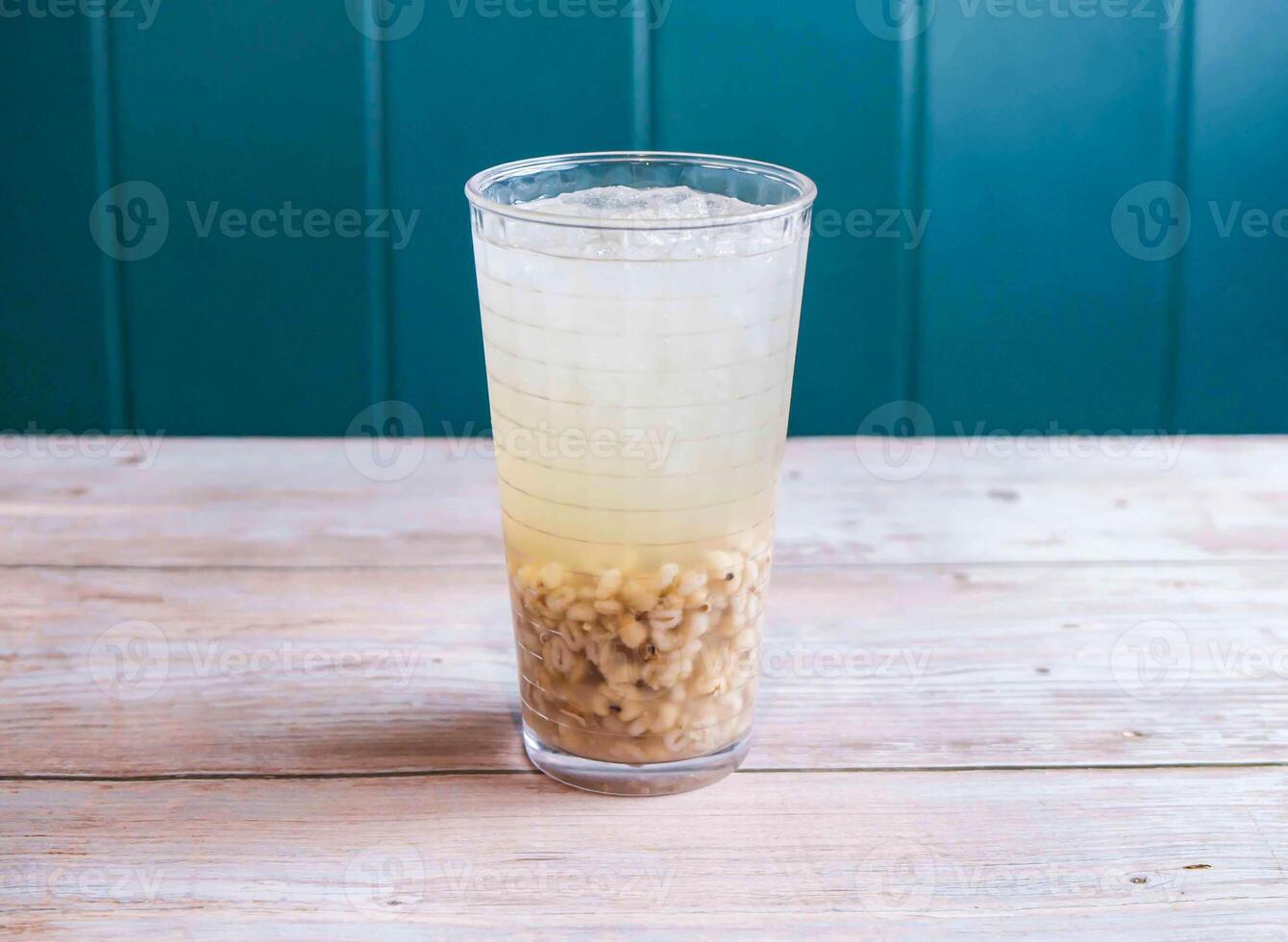 Refreshing Iced Barley Water with ice cube served in glass isolated on wooden background side view of Hong Kong drink photo