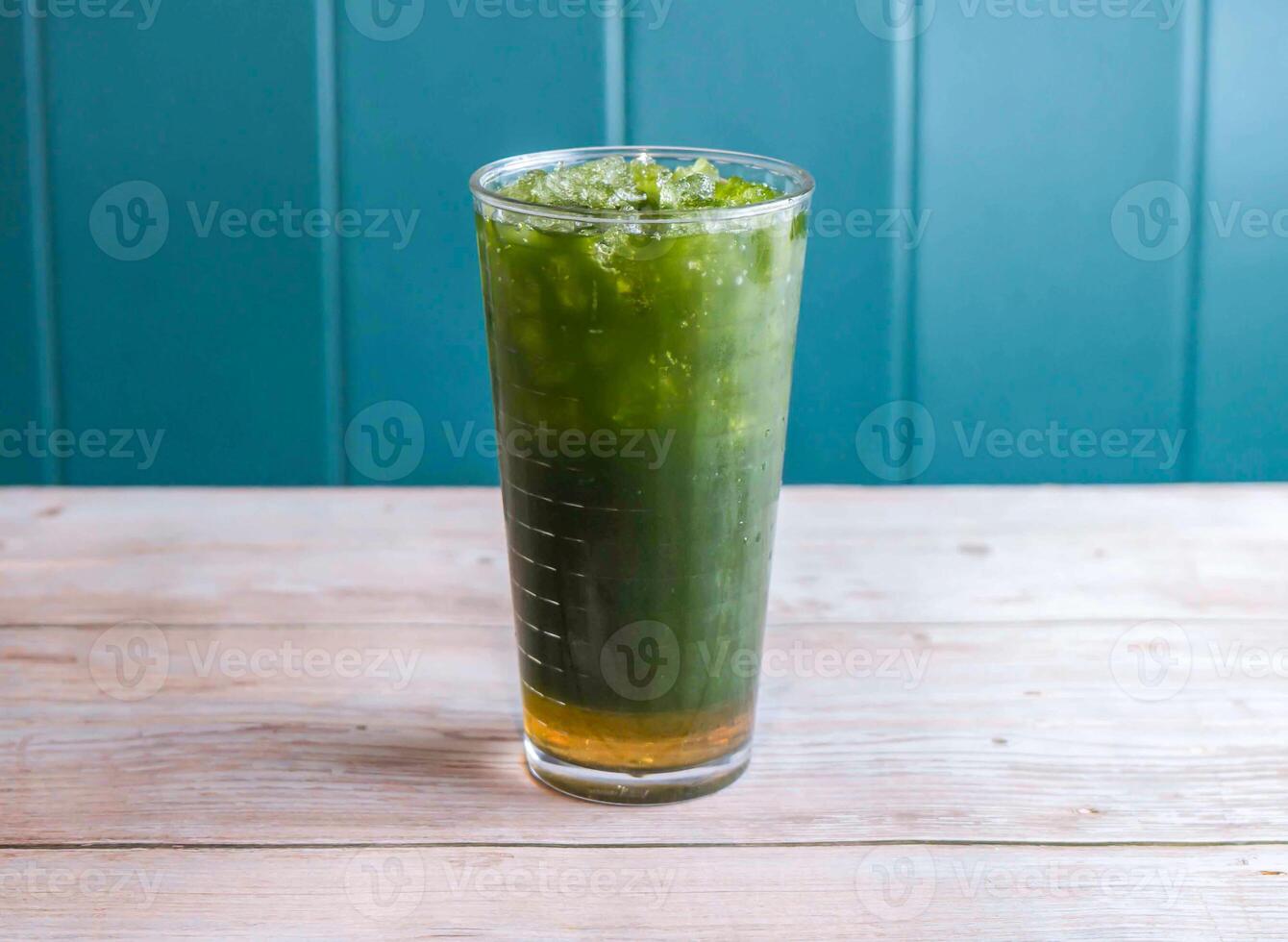 Iced Matcha Lemonade, Icepear and Centella Asiatica drink with ice cube served in glass isolated on wooden background side view of Hong Kong drink photo