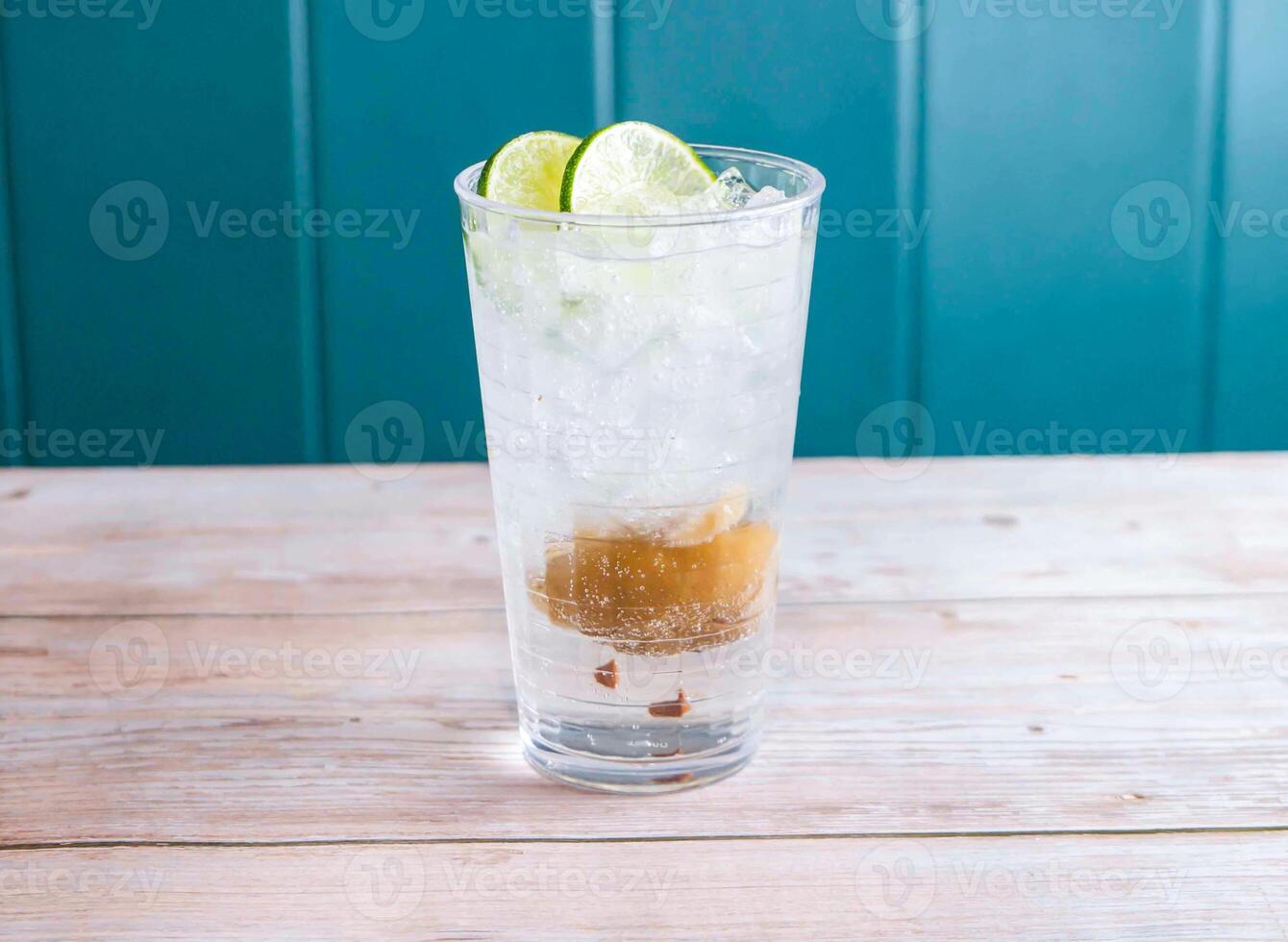 Salted Lemon and Lime Soda with ice cube served in glass isolated on wooden background side view of Hong Kong drink photo