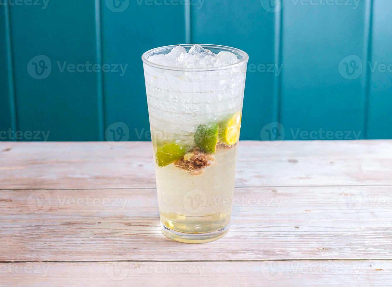Citrus and Plum Soda with iced cubes served in glass isolated on wooden background side view of Hong Kong drink photo