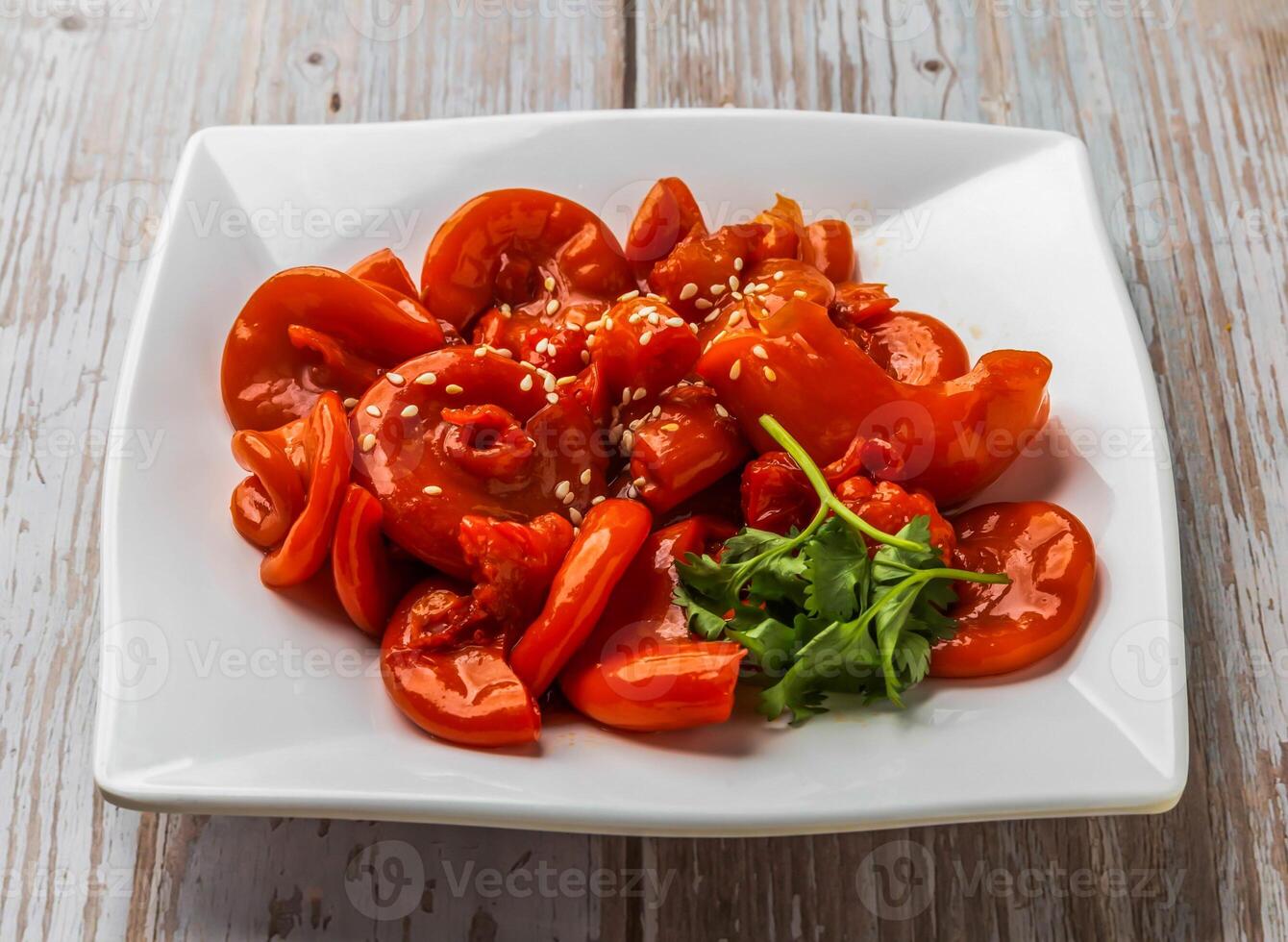 Spicy Pig Oviduct with rich sauce, sesame seeds and cilantro served in plate on Wood Table Close up Side view of Hong Kong food photo