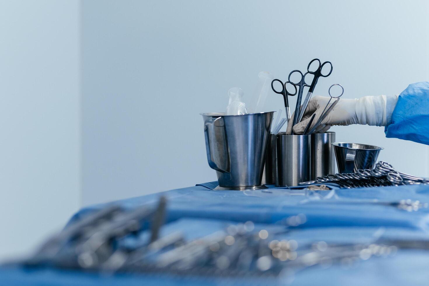 Surgical instruments in the operating room. A nurse in a surgical suit and gloves. Steel medical instruments ready to be used. Surgery and emergency concept. Medicine. Free copy space, banner, ads photo