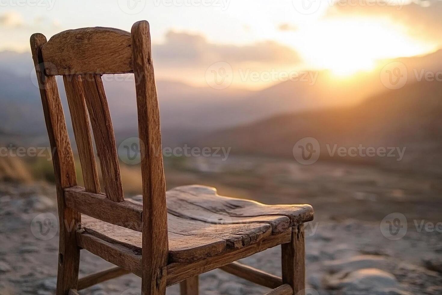 A wooden chair sits on the side of a mountain photo