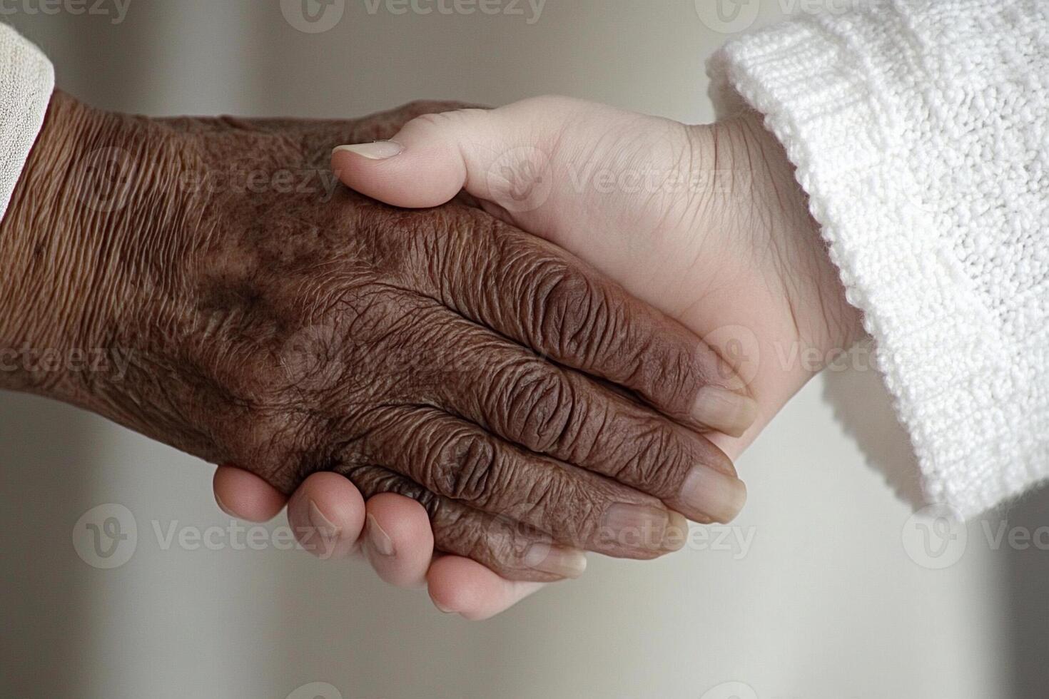 An elderly person shaking hands with a young person photo