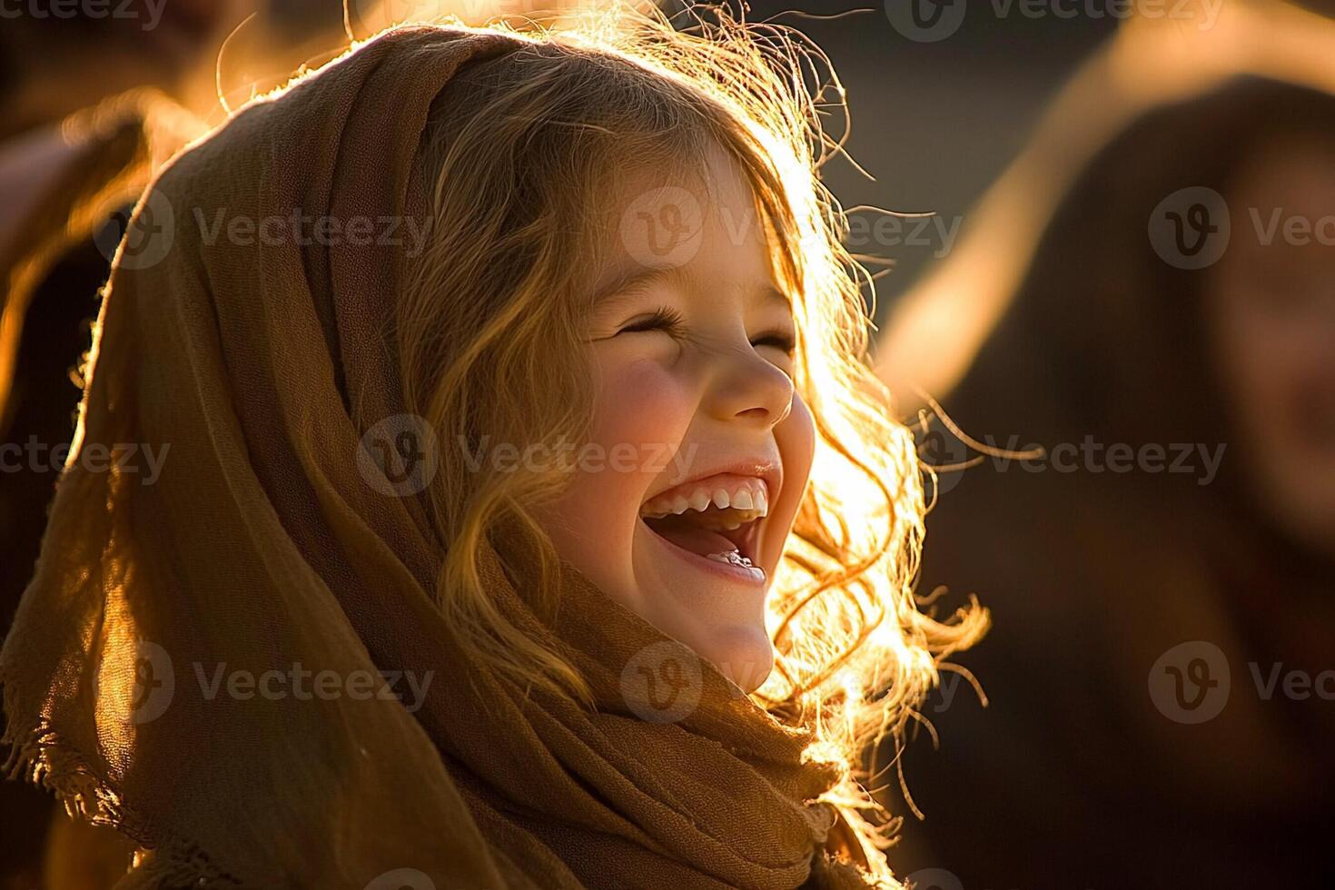 A little girl is laughing while wearing a scarf photo