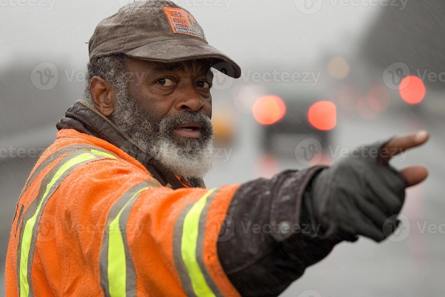 A man in an orange vest pointing at something photo