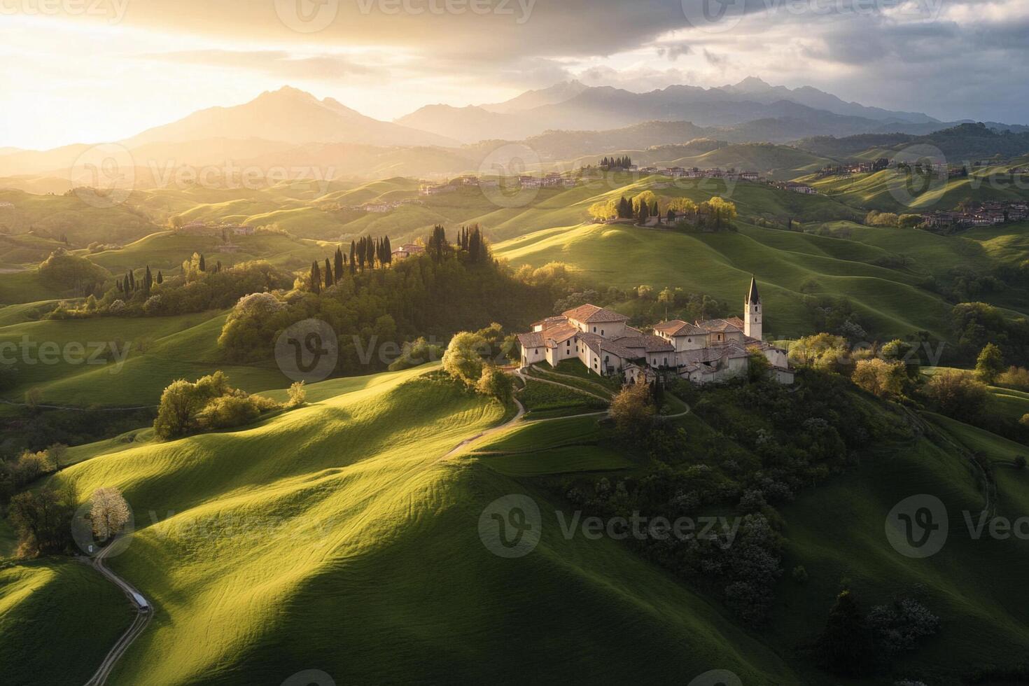 The sun sets over a green hillside with a church photo