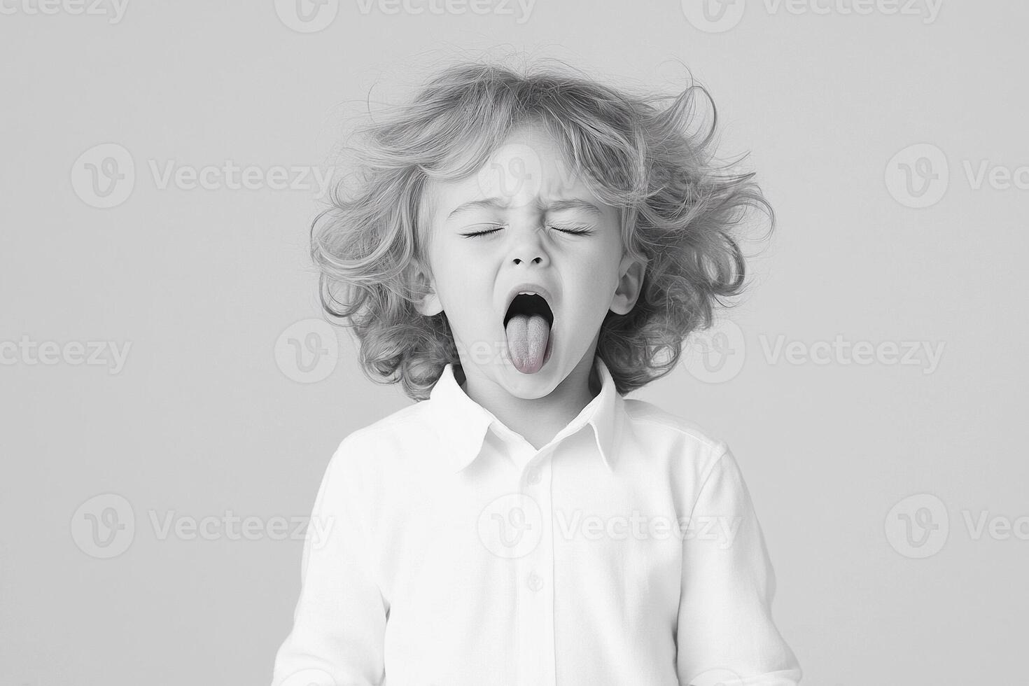 A young boy with his mouth open and his tongue out photo