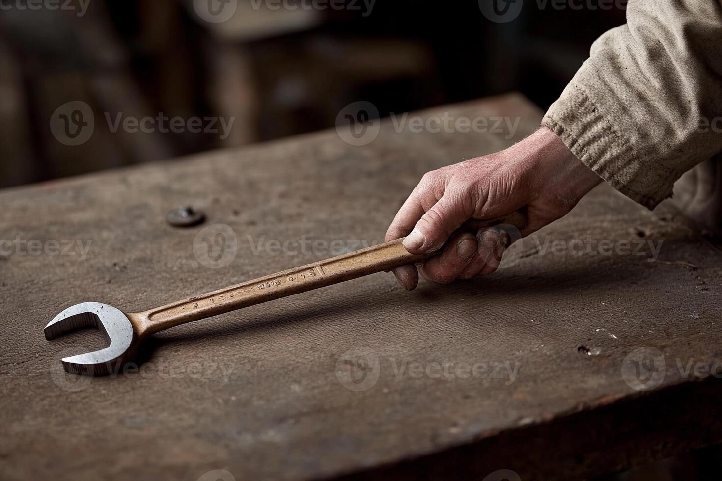 A person holding a wrench on a table photo