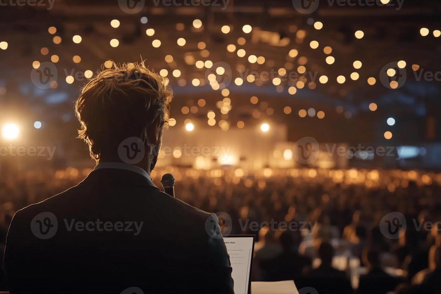 A man in a suit is standing in front of a crowd photo