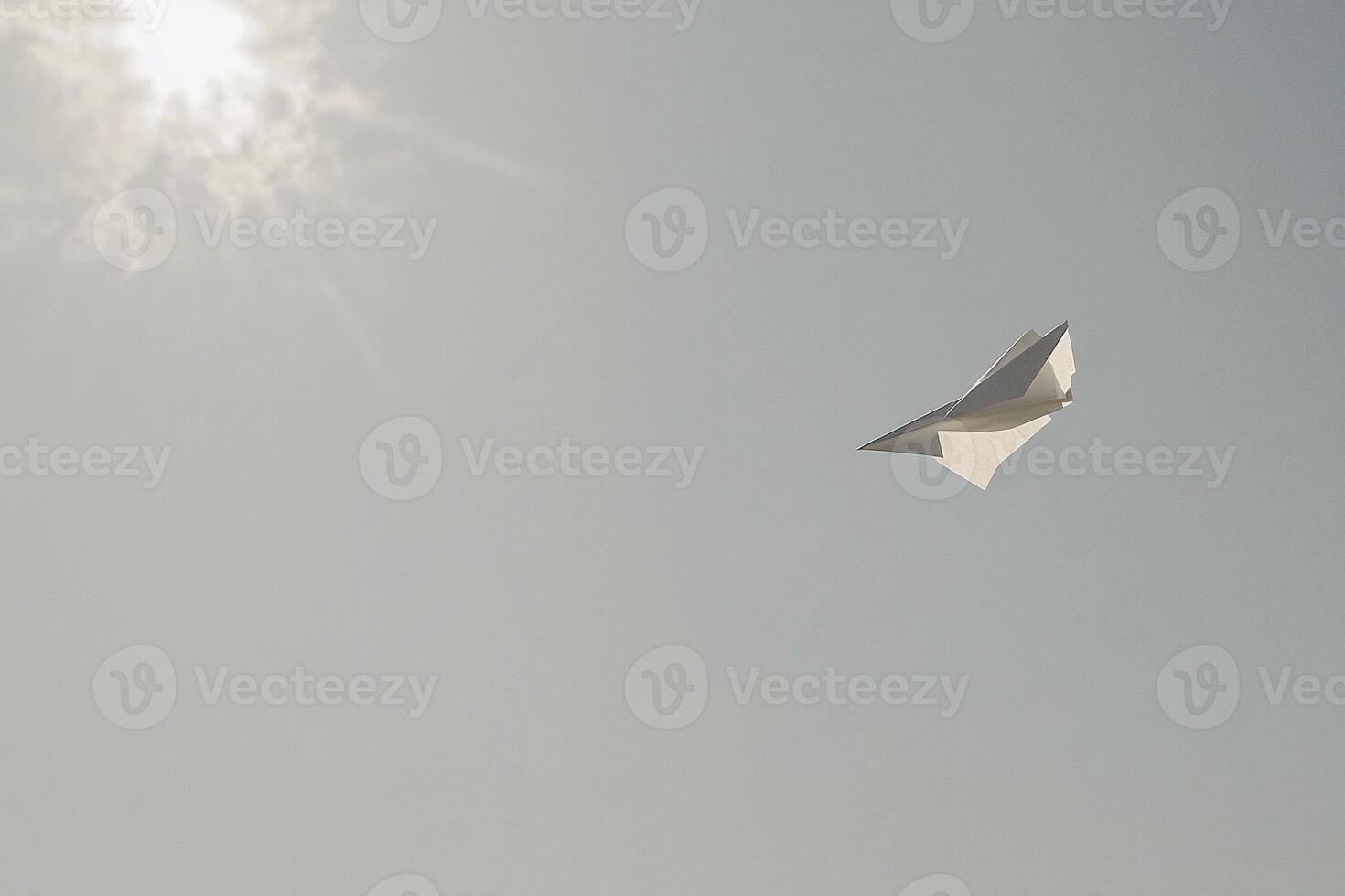 A paper airplane flying in the sky photo