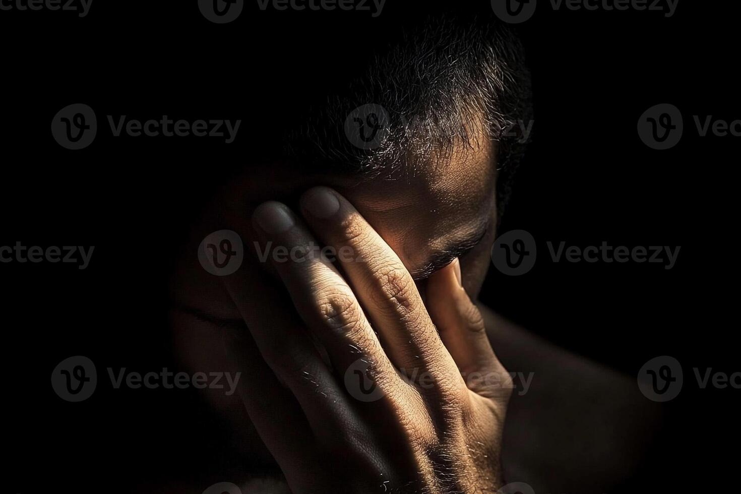 A man is holding his hands to his face photo