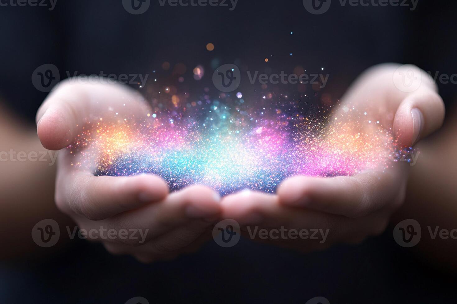 Hands holding colorful glowing particles photo