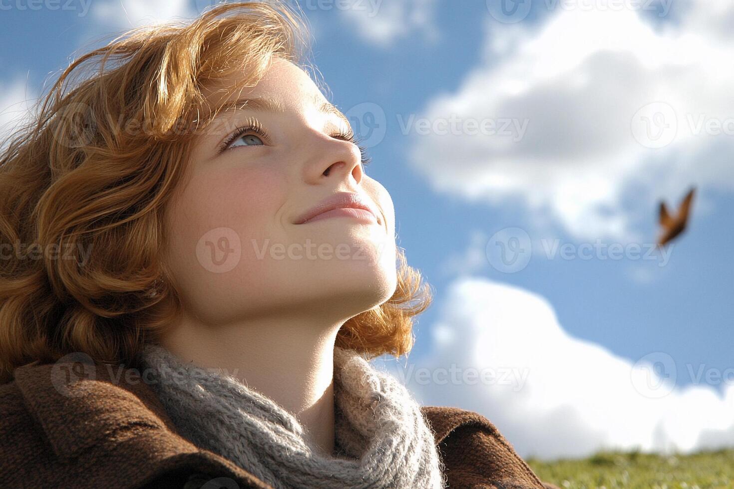 A woman looking up at a bird flying in the sky photo
