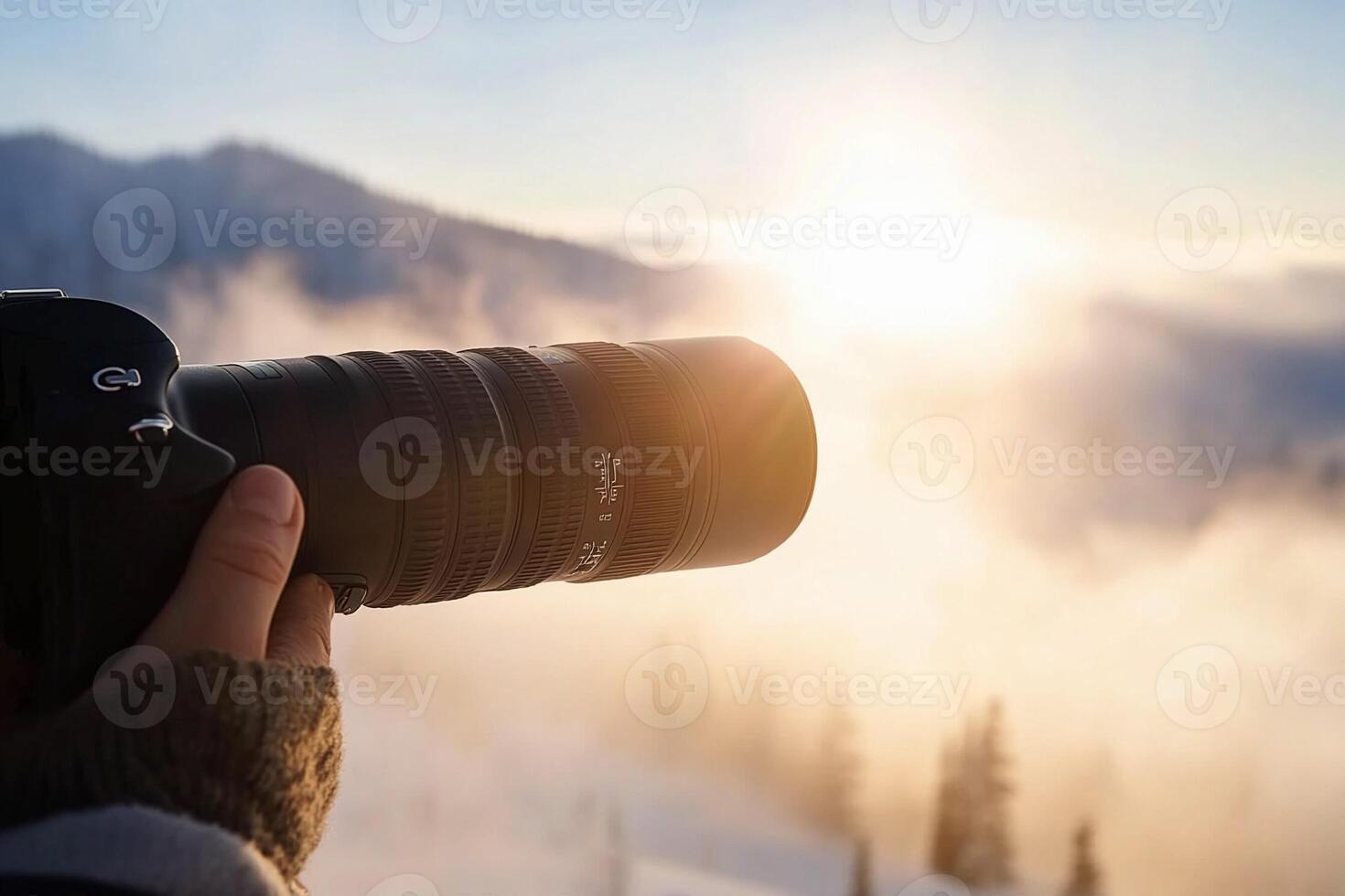 A person holding a camera with the sun in the background photo