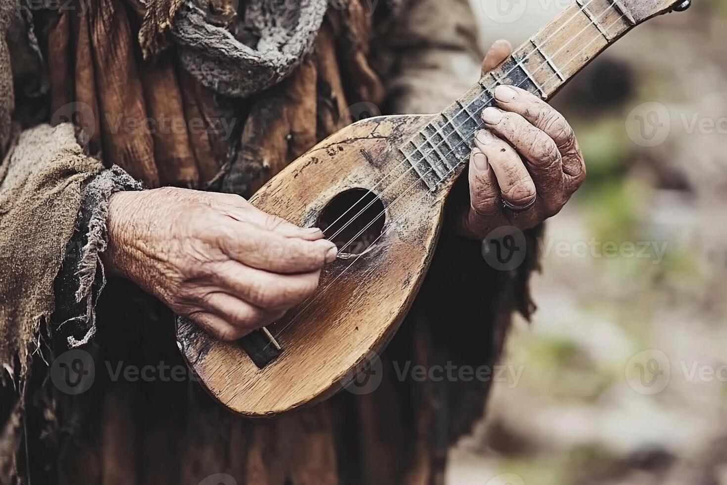 An old man playing a guitar in the woods photo