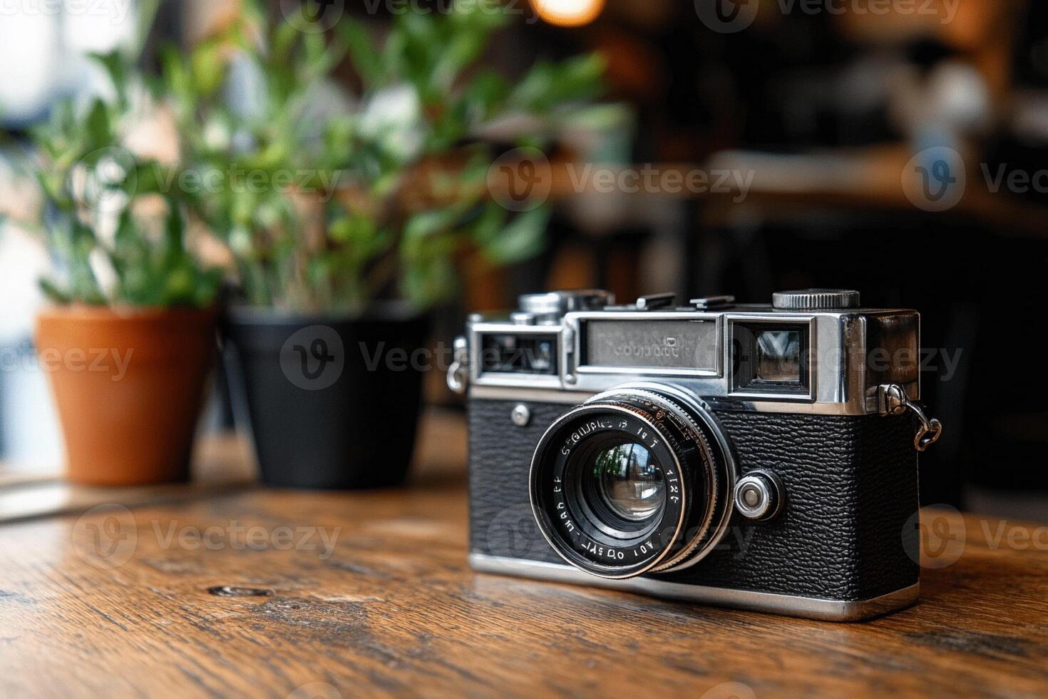 A vintage camera sits on a wooden table photo