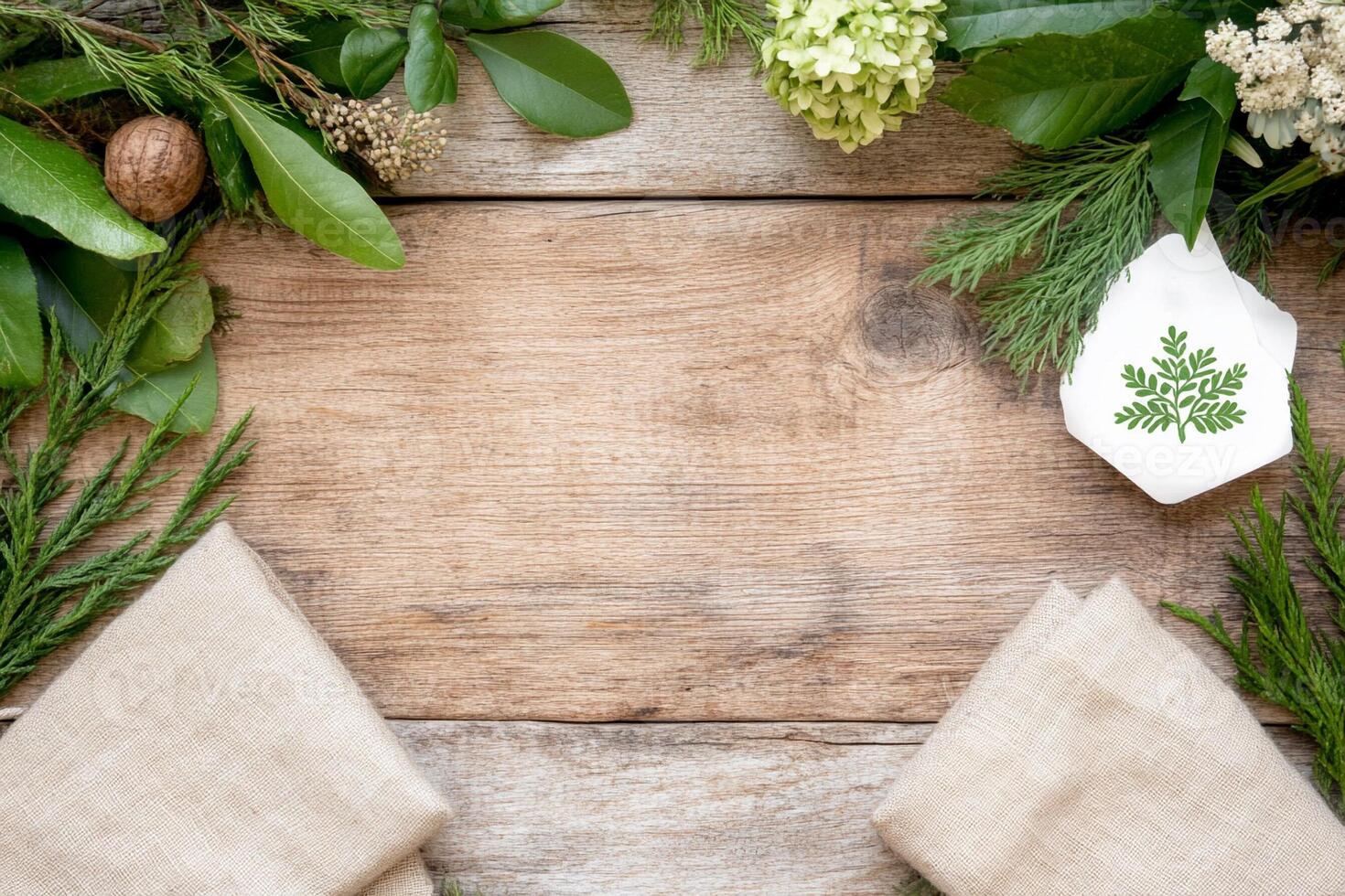 A wooden table with napkins and green leaves photo
