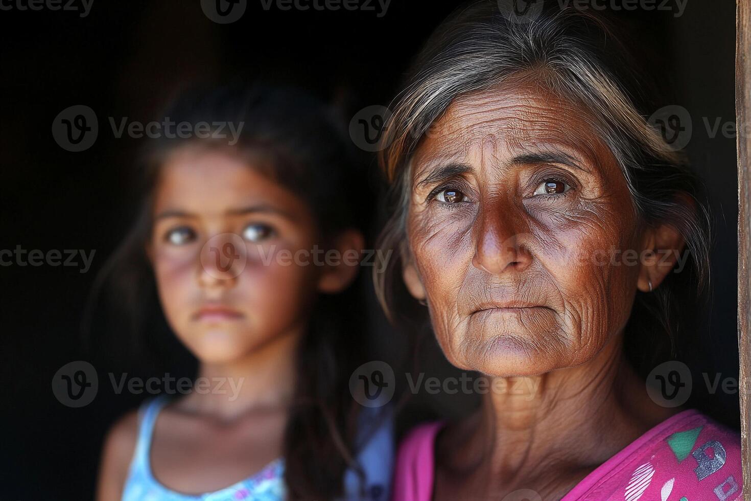 An older woman and a young girl standing together photo